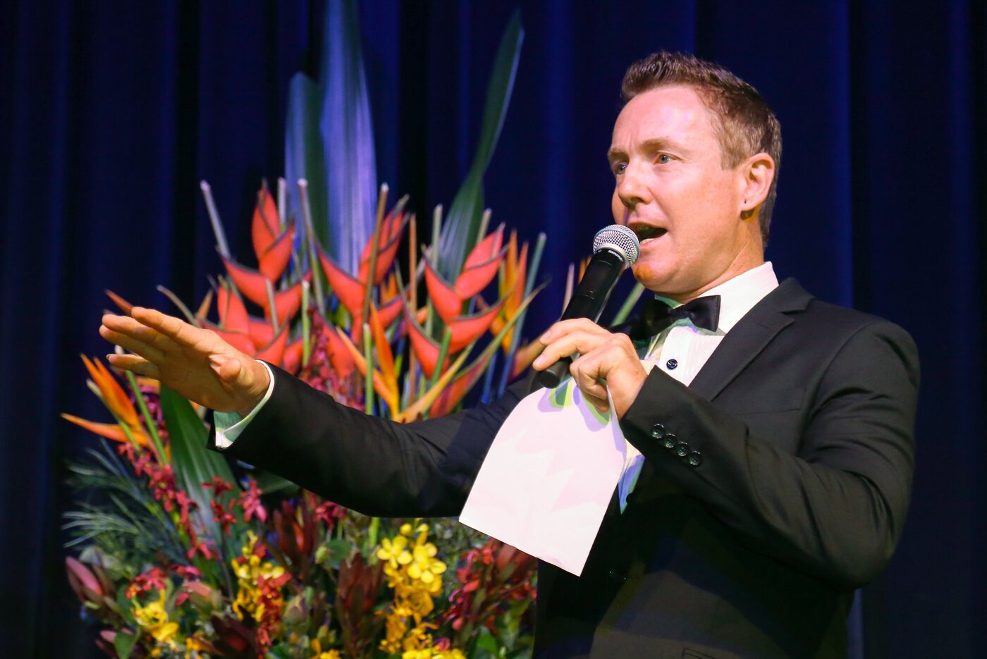 Tony Morrison hosting a black-tie gala event on stage